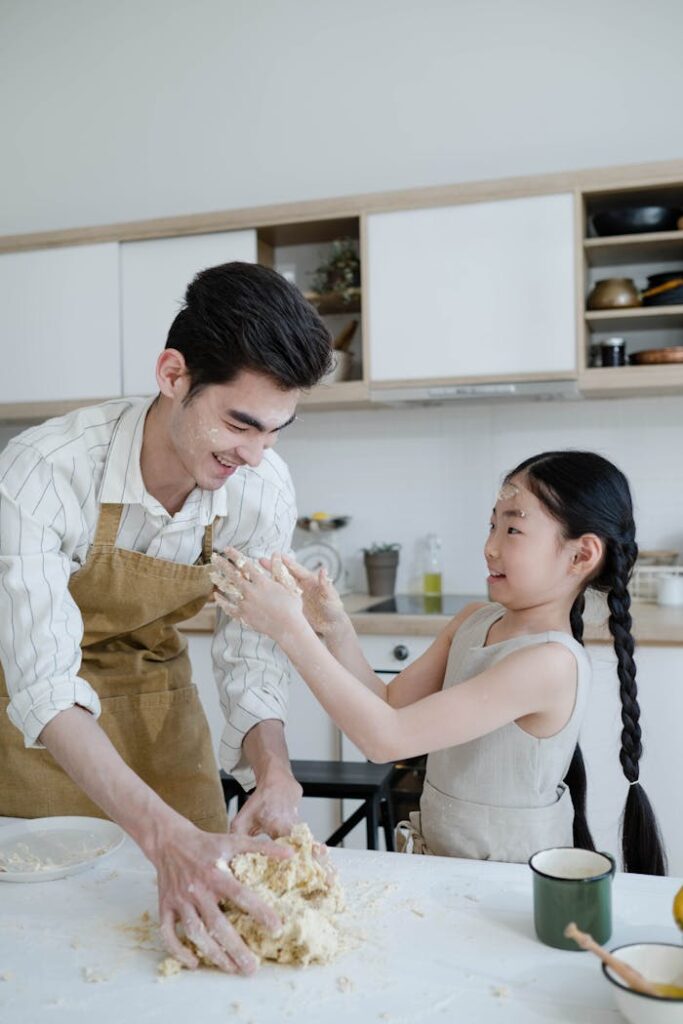 girl-and-a-man-kneading-dough-on-the-kitchen-counter-8189428